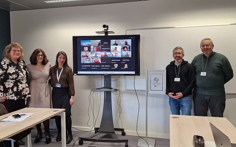 Image presenting poeple in person and online participating at the kickoff